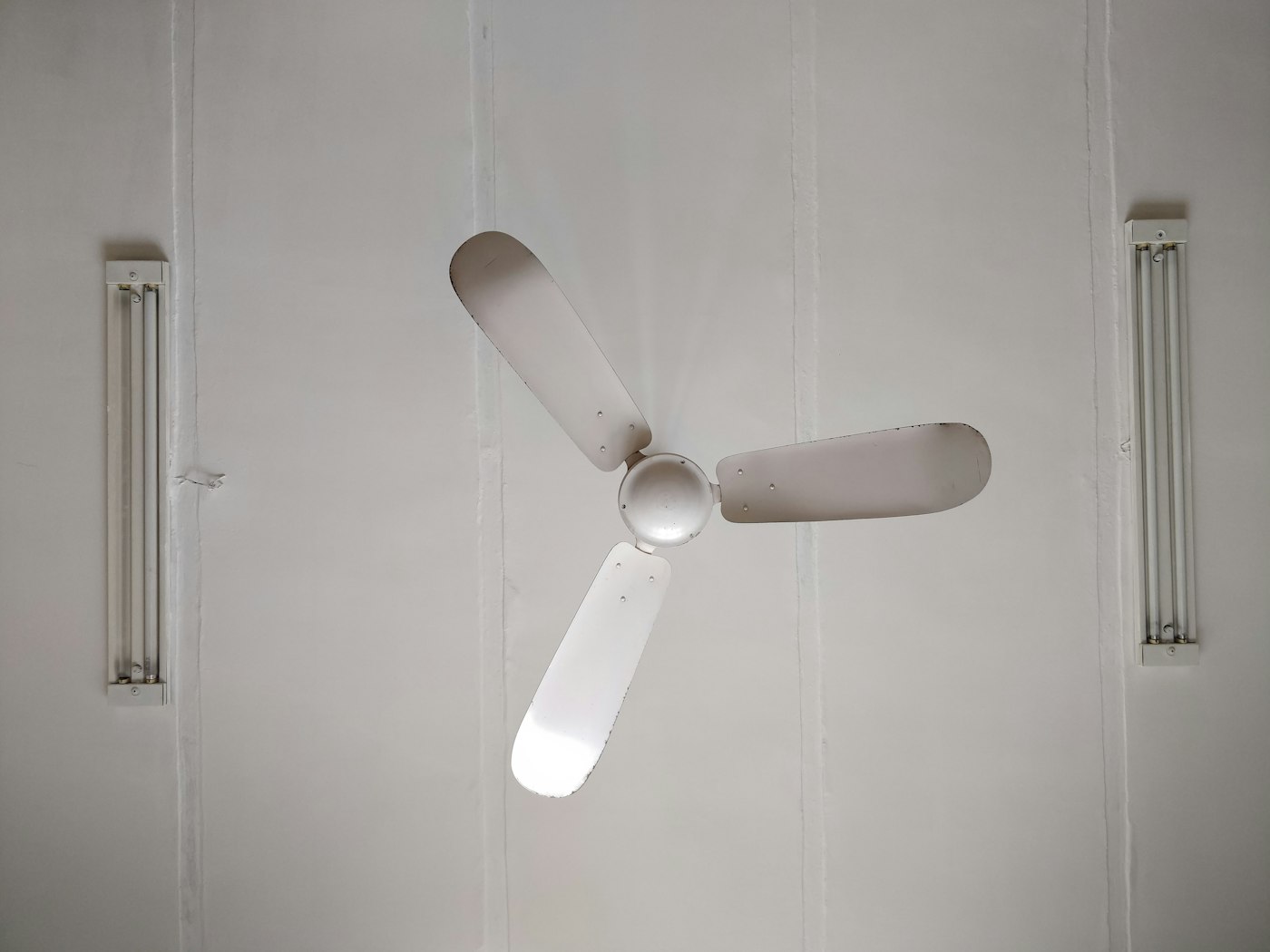 Instalación de ventiladores de techo de bajo consumo Ventilador de techo blanco de tres aspas ya instalado en el techo